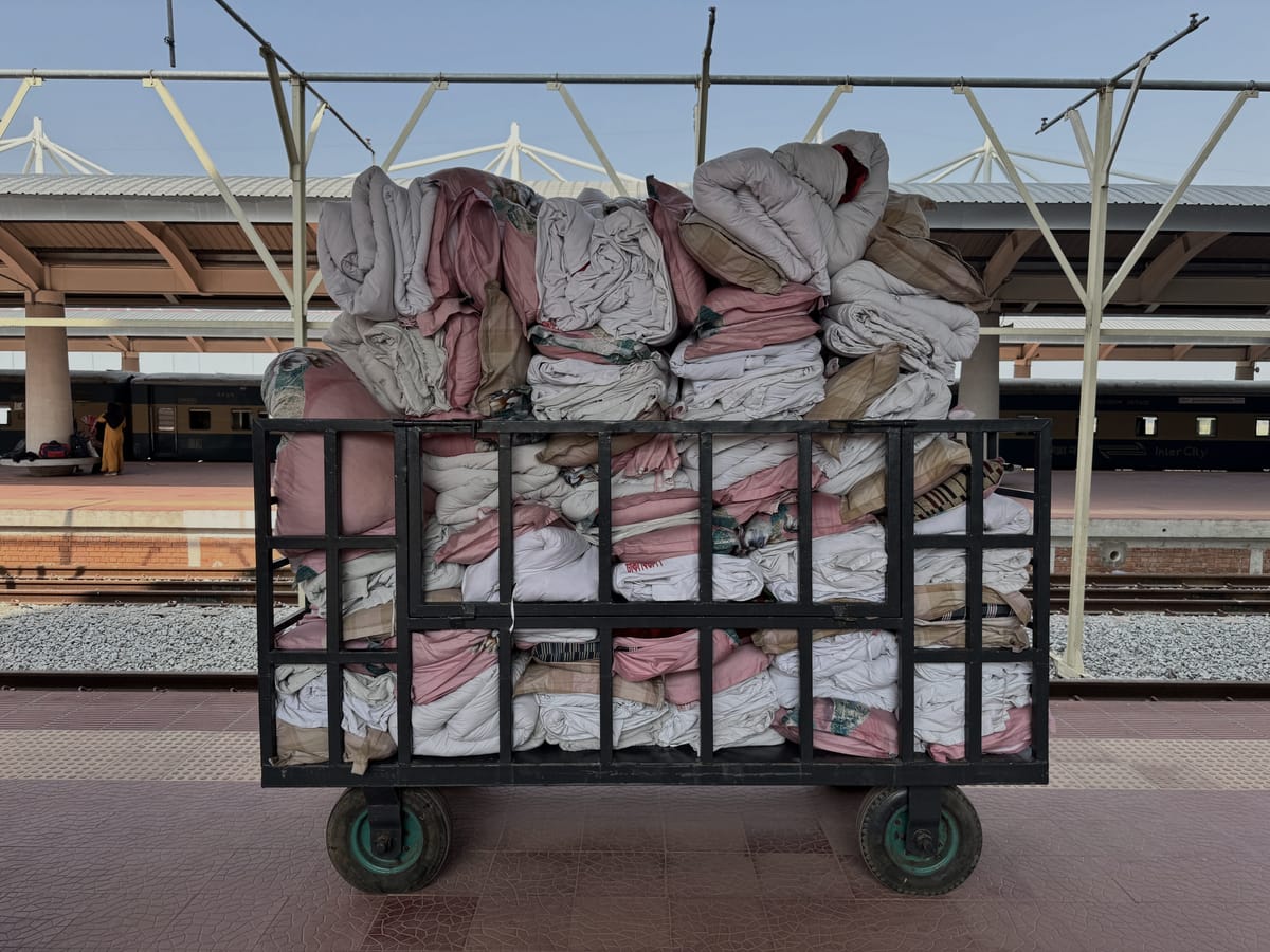 Carrinho de hotel cheio de roupa de cama dobrada